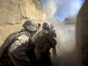 Marines take cover as their explosives burst open an Afghan home in Farah Province