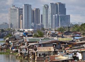Slums in Manila with skyscrapers in the distance